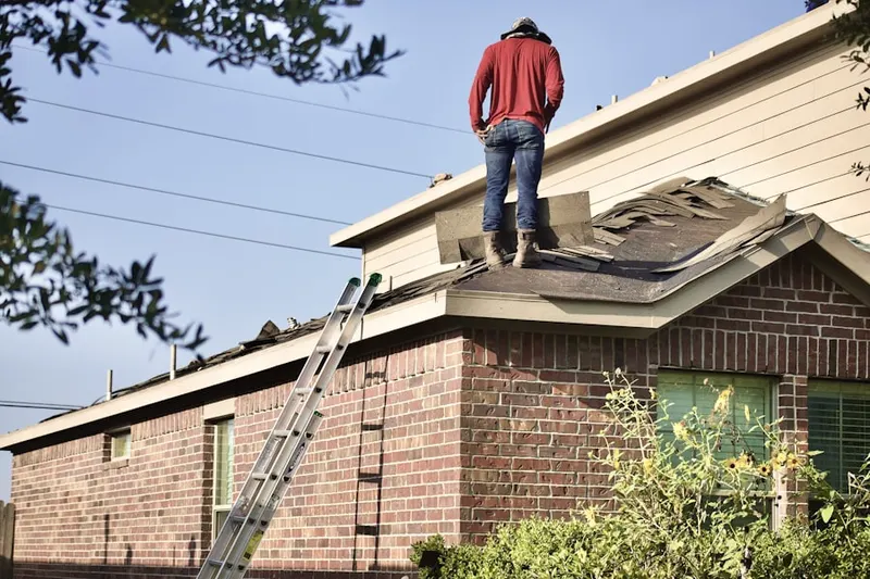 Professional roofer working on a residential roof in West Farms